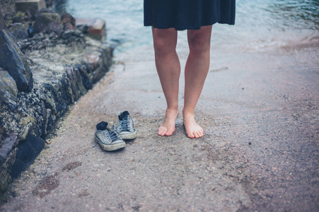 一个光着脚的女人鞋子站在滑滑梯上