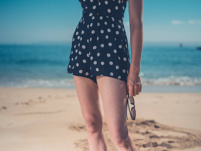 海滩上一位年轻女子戴着戴着太阳镜的剪影