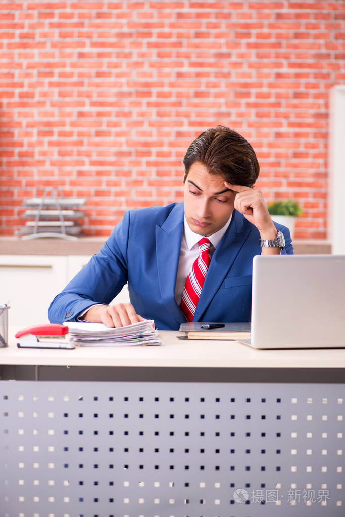 在办公室工作的年轻英俊的员工