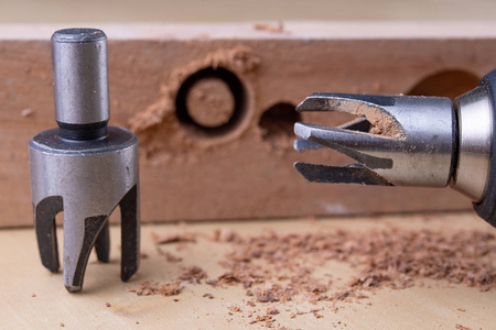 木工车间用特殊的钻头钻孔. 细木工配件的修理工作. 光线背景.照片