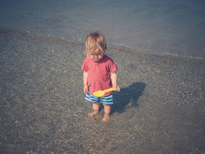 一个可爱的小孩正在海滩上玩耍