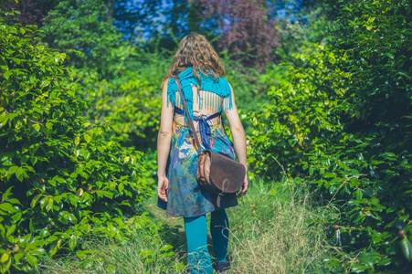 一个穿着不寻常服装的年轻女子正在森林里散步