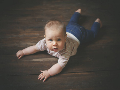 一个小婴儿躺在木地板上