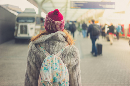 站在车站的戴着冬帽的年轻女子的后视镜