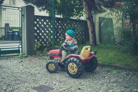 一个小孩正骑着玩具拖拉机