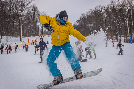 男性滑雪板弯曲和刹车喷洒松散的深雪在自由坡。