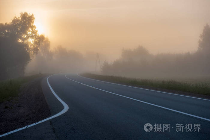 空的柏油路，白线在七月的早晨雾蒙蒙