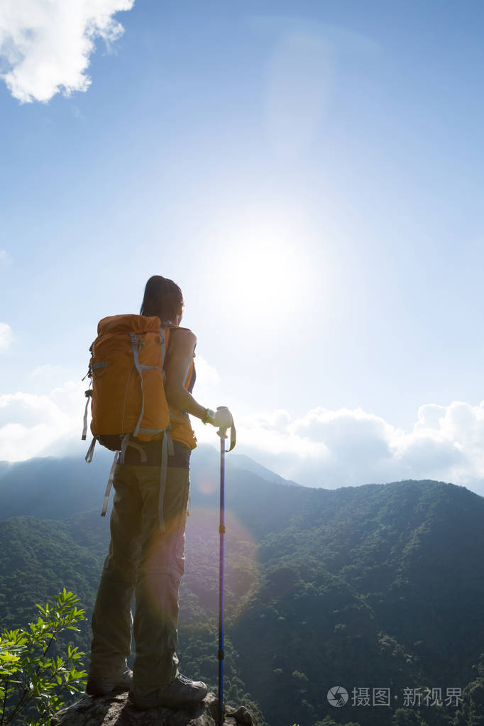 在山顶欣赏风景的成功女徒步旅行者