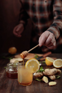 一杯加蜂蜜柠檬和薄荷的姜茶在旧木桌上。 选择性聚焦。