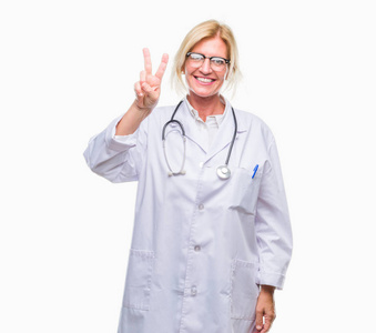 中年金发医生女人在孤立的背景上显示和手指第二，同时微笑自信和快乐。