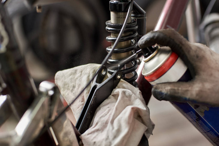 在自行车修理厂工作的男机修工戴防护手套