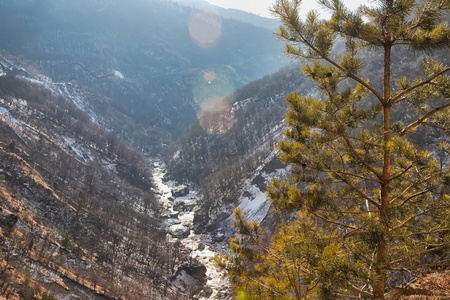 山峡的俯视图，山峡上流淌着一条山河。 在镜框里用一缕阳光射向光线