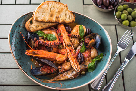 带面包和开胃菜的烤海鲜菜放在木桌上地中海