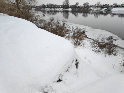 美丽的冬天景观在河岸上，许多白雪和河流