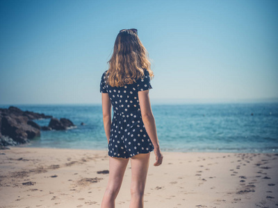 夏天，一位美丽的年轻女子站在海滩上