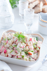 沙拉与蟹棒和米饭在一个小沙拉碗在白色的桌子上选择性的焦点