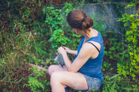 一个年轻的孕妇坐在她的花园里，旁边是一棵黑醋栗