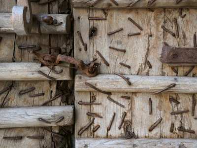 旧木门内生锈钉子和金属结构的特写细节。