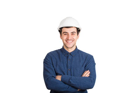 开朗自信的年轻人，工程师的手臂交叉着，戴着防护头盔，微笑着看着白色背景上孤立的摄像机。