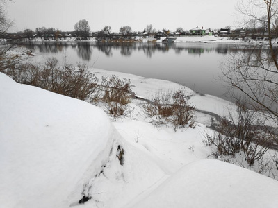 美丽的冬天景观在河岸上，许多白雪和河流