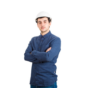 严肃自信的年轻人工程师戴着防护头盔，双手交叉，看着白色背景上孤立的摄像机。