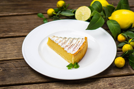 一块柠檬蛋糕，放在木桌上的白色盘子里，里面有配料