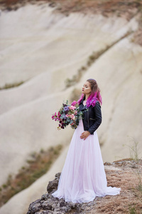 新娘有创造性的头发着色，看远处的自然。 土耳其卡帕多西亚山区一位头发鲜艳的女人的肖像。 大自然的婚礼
