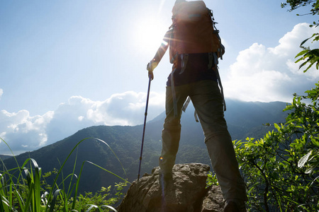 成功的女人徒步旅行到山顶