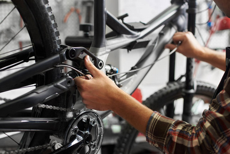 男机修工在自行车修理车间修理工在车间修理自行车，穿着防护工作服