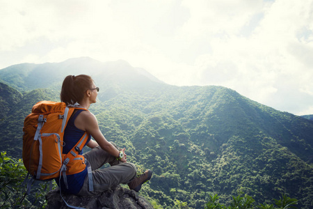 在山顶欣赏风景的成功女徒步旅行者