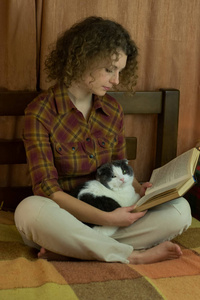 女孩和一只猫在床上看书