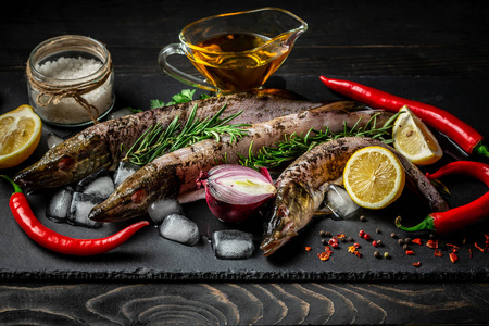 鱼梭子菜的食物背景，用各种配料烹饪。 生矛与油，草药和香料在切割板顶部视图。 健康食品或饮食营养概念。
