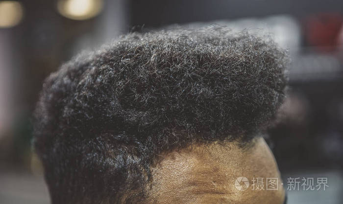 理发店里年轻的黑人头发理发店沙龙里把没刮过胡子的非洲男人的卷发