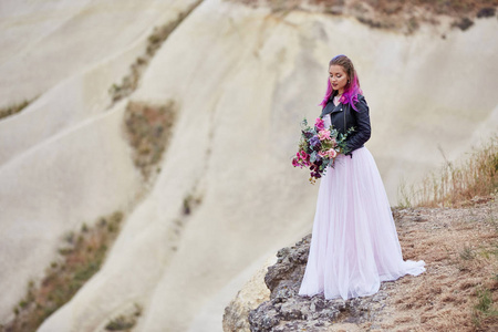 新娘有创造性的头发着色，看远处的自然。 土耳其卡帕多西亚山区一位头发鲜艳的女人的肖像。 大自然的婚礼