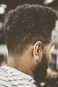 理发店年轻黑人的脖子和脖子。非洲人在理发店理发和修剪胡须。理发店的男性美容处理过程。