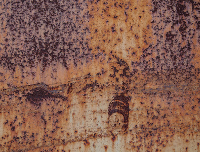 生锈。 旧生锈金属片的质地和背景。 生锈的铁有划痕和油漆残留物。