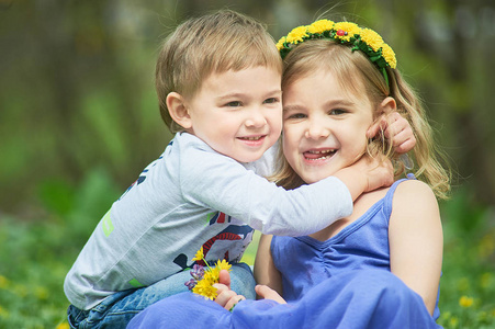 s games, leisure. Two children are sitting on green meadow and s