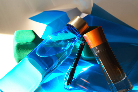创意布局由哑铃, 男子香水, 钢笔和水瓶运动折叠的蓝色纸。情人节生日生活方式的最小风格的礼物概念