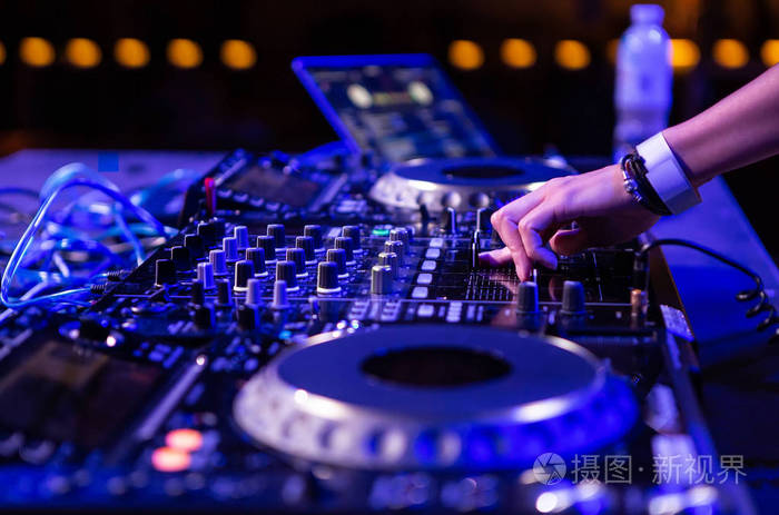 派对dj女孩在深蓝色灯光下将音乐与专业音频设备安装在舞台上女光盘
