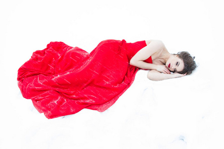 穿着红色晚礼服的小女孩在雪地上摔倒