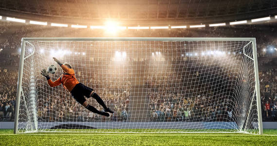 守门员试图从一个进球中拯救一个职业足球体育场.