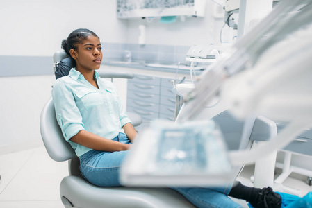 女病人坐在椅子上，在牙科诊所就诊。牙科，口腔科，牙齿护理的女性