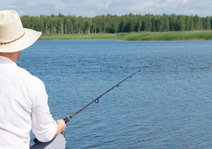 一个人在蓝水后景的背景下钓鱼