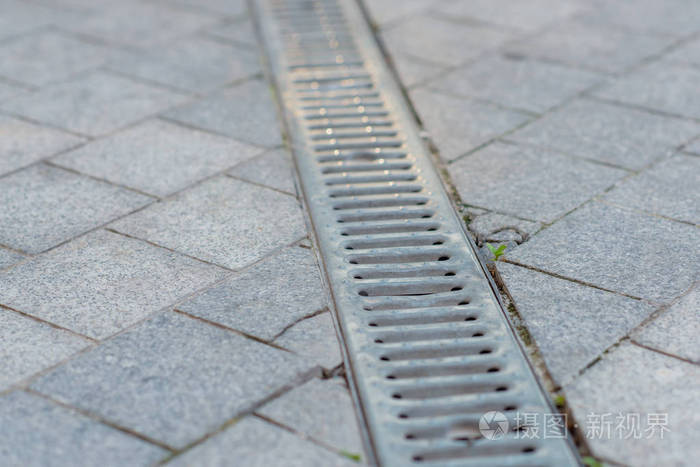 铺上灰色的石板用金属烤架排水人行道下水道排水排水要素建筑