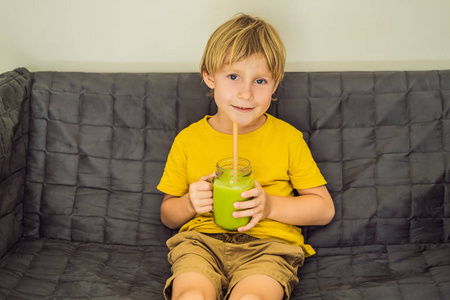 这个男孩正在喝绿茶拿铁和杯子里的冰。自制的冰抹茶拿茶与牛奶零浪费