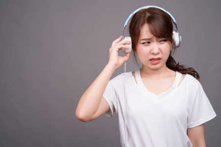 年轻美丽的亚洲女人戴着音乐耳机