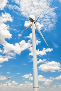风力发电机在明亮的多云天空中。生态能源概念。
