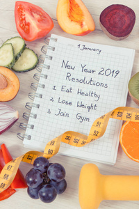 2019年新年目标用记事本和新鲜熟透的蔬菜水果书写