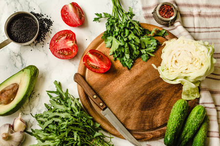 新鲜的花园蔬菜，西红柿和黄瓜在烹饪桌上。 俯视。清洁饮食。 饮食食品概念。 健康的食物背景。