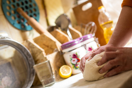 厨房里用面团做面包的女性手